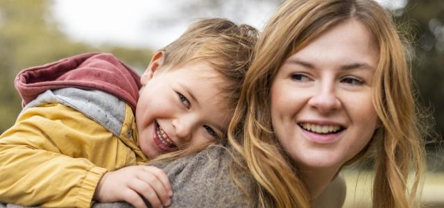 happy mother holding kid back