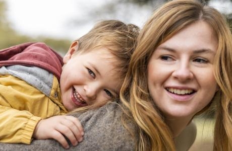 happy mother holding kid back